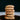 Stack of sunflower cookies on a white plate with a black background