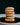 Stack of sunflower cookies on a white plate with a black background
